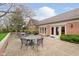 Outdoor patio area featuring patio seating, manicured landscaping, and a brick building at 8535 Olde Mill Circle West Dr, Indianapolis, IN 46260