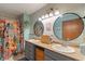 Bathroom featuring double sinks, round mirrors, and stylish floral accents at 8747 Knotty Pine Ct, Indianapolis, IN 46227