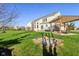 Large, well-manicured backyard with a sandbox, a pergola-covered patio, and a two-story home at 8965 Snowberry Ct, Zionsville, IN 46077