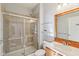 Bright bathroom featuring a glass enclosed shower, floating shelves, and a wooden framed mirror at 8965 Snowberry Ct, Zionsville, IN 46077