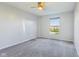 A bedroom with neutral paint, gray carpet, ceiling fan, and a large window that lets in natural light at 8965 Snowberry Ct, Zionsville, IN 46077