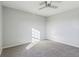 A bedroom with neutral paint, gray carpet, ceiling fan, and a large window that lets in natural light at 8965 Snowberry Ct, Zionsville, IN 46077