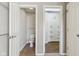 Hallway view of the powder room with wood-look floors, and walk-in closet at 8965 Snowberry Ct, Zionsville, IN 46077