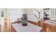 Living room with hardwood floors, a gray rug, and an oversized chair at 8965 Snowberry Ct, Zionsville, IN 46077