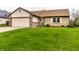 Well-maintained home featuring lush green lawn, mature tree, and attached two car garage at 8973 Sunningdale Blvd, Indianapolis, IN 46234