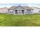 Back exterior of a home showcasing the spacious yard, covered porch, and modern blue siding at 9925 Glendon Ct, McCordsville, IN 46055