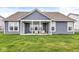 Back exterior view of a blue home with white trim, a covered porch with chairs, and a green lawn at 9925 Glendon Ct, McCordsville, IN 46055