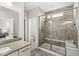This bathroom features a tiled shower with bench and glass door, a sink with quartz countertop and gray flooring at 9925 Glendon Ct, McCordsville, IN 46055