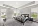 Primary bedroom with tray ceiling features large windows with backyard views and a decorative floral bedspread at 9925 Glendon Ct, McCordsville, IN 46055