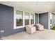 Close-up of a covered patio with two covered chairs and a small side table; lots of natural light at 9925 Glendon Ct, McCordsville, IN 46055