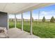View from the covered patio, overlooking the backyard with a black iron fence and young trees at 9925 Glendon Ct, McCordsville, IN 46055