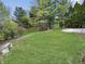 Spacious backyard featuring lush green lawn, mature trees, and a concrete patio on the right at 10200 Cheswick Ln, Fishers, IN 46037