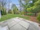 View of backyard from patio, featuring green lawn, mature trees, and partially wooded area at 10200 Cheswick Ln, Fishers, IN 46037