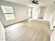 Sunlit bedroom with new light wood flooring, white walls, and two windows at 10200 Cheswick Ln, Fishers, IN 46037