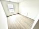 Bright bedroom with wood-look flooring, neutral walls, and a window, perfect for creating a cozy and inviting atmosphere at 10200 Cheswick Ln, Fishers, IN 46037
