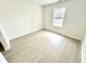 Bright and airy bedroom featuring wood-look flooring, a window with blinds, and neutral walls, creating a comfortable living space at 10200 Cheswick Ln, Fishers, IN 46037