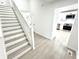 Welcoming entryway with staircase that offers a glimpse into the kitchen with white cabinets at 10200 Cheswick Ln, Fishers, IN 46037