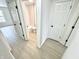 Bright hallway with doors leading to a full bathroom and bedroom, featuring light-colored flooring and neutral walls at 10200 Cheswick Ln, Fishers, IN 46037