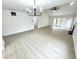 Open-concept living room with vaulted ceilings, fireplace, and light wood-look floors at 10200 Cheswick Ln, Fishers, IN 46037