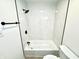 Bathroom shower featuring white tiled walls, black fixtures, and a classic tub, combining style with functionality at 10200 Cheswick Ln, Fishers, IN 46037