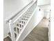 Clean, modern staircase featuring a white railing and light wood-look flooring at 10200 Cheswick Ln, Fishers, IN 46037