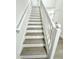 Bright staircase featuring white risers and wooden treads, accented by a white banister, offering a stylish transition between floors at 10200 Cheswick Ln, Fishers, IN 46037