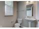 Cozy half bathroom with a pedestal sink, toilet, and window providing natural light at 10602 Pintail Ln, Indianapolis, IN 46239