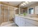 Bathroom with tile shower, glass doors, double vanity with quartz countertop at 10602 Pintail Ln, Indianapolis, IN 46239