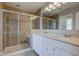 Bathroom showcasing a glass-enclosed shower and a double vanity with ample cabinet space at 10602 Pintail Ln, Indianapolis, IN 46239