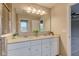 Well-lit bathroom featuring a double sink vanity with stone countertops and a large mirror at 10602 Pintail Ln, Indianapolis, IN 46239