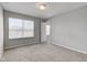 A simple bedroom featuring carpeted floors, gray walls, natural light, and an open door at 10602 Pintail Ln, Indianapolis, IN 46239