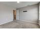 A simple bedroom featuring carpeted floors, gray walls, natural light, and an open door to bathroom at 10602 Pintail Ln, Indianapolis, IN 46239