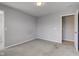 A simple bedroom featuring carpeted floors, gray walls, natural light, and an open door at 10602 Pintail Ln, Indianapolis, IN 46239