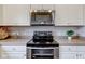 Stainless steel range and microwave are nestled between white cabinets in this clean kitchen at 10602 Pintail Ln, Indianapolis, IN 46239