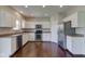 Bright kitchen with stainless steel appliances, white cabinets, and hardwood flooring at 10602 Pintail Ln, Indianapolis, IN 46239