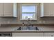 Kitchen sink view with stainless steel hardware, a window and white cabinetry at 10602 Pintail Ln, Indianapolis, IN 46239
