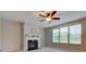 Bright living room showcasing a fireplace, ceiling fan, and large windows offering pleasant outdoor views at 10602 Pintail Ln, Indianapolis, IN 46239