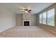 Spacious living room featuring a cozy fireplace, carpeted flooring, and a ceiling fan for added comfort at 10602 Pintail Ln, Indianapolis, IN 46239