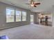 Bright living room with large windows, ceiling fan, and seamless transition to the kitchen at 10602 Pintail Ln, Indianapolis, IN 46239
