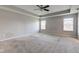 Spacious main bedroom with neutral carpet, ceiling fan, and double windows for natural light at 10602 Pintail Ln, Indianapolis, IN 46239
