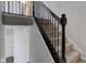 Carpeted staircase with decorative wrought iron spindles and dark stained wood handrail at 10602 Pintail Ln, Indianapolis, IN 46239