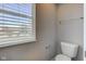 Small half-bathroom area featuring a toilet and a window with blinds at 10602 Pintail Ln, Indianapolis, IN 46239