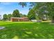 Expansive backyard with lush green lawn and mature trees provides ample space for outdoor activities at 11054 N Shelby 490 W, New Palestine, IN 46163