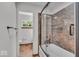 Updated bathroom showcasing tub with decorative tiled walls and glass door at 11054 N Shelby 490 W, New Palestine, IN 46163