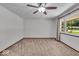 A carpeted bedroom with a ceiling fan, curtains, and a view to the tree lined front yard at 11054 N Shelby 490 W, New Palestine, IN 46163