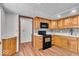 Classic kitchen features wood cabinets, black appliances, and modern backsplash at 11054 N Shelby 490 W, New Palestine, IN 46163