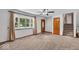 A carpeted living room is shown, with a staircase, front door and large picture window at 11054 N Shelby 490 W, New Palestine, IN 46163