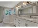 Bright bathroom featuring a double vanity with marble countertop, decorative mirror, and separate tub and shower at 11599 Braemar Ct, Carmel, IN 46032