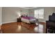 Spacious bedroom with hardwood floors, a cozy bed, a window, and a bedside table with lamp at 11599 Braemar Ct, Carmel, IN 46032