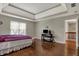 Large bedroom with tray ceiling, hardwood floors, lots of natural light, and neutral walls at 11599 Braemar Ct, Carmel, IN 46032